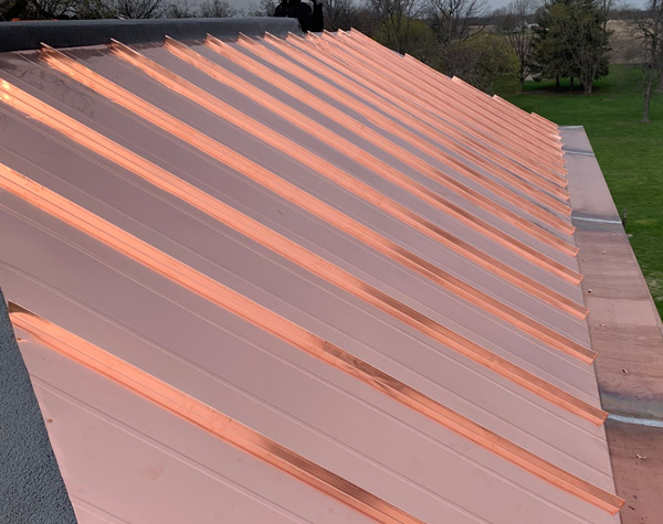 A view of the side of a copper standing seam metal roof on a home.