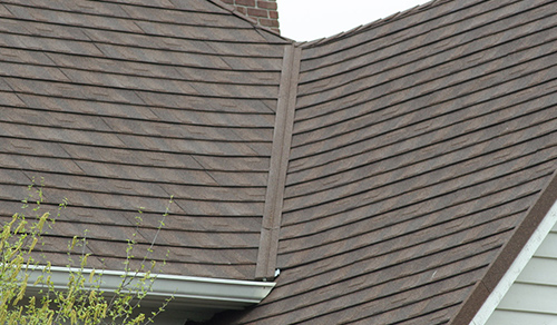 A detailed look at a home with brown metal shingles.