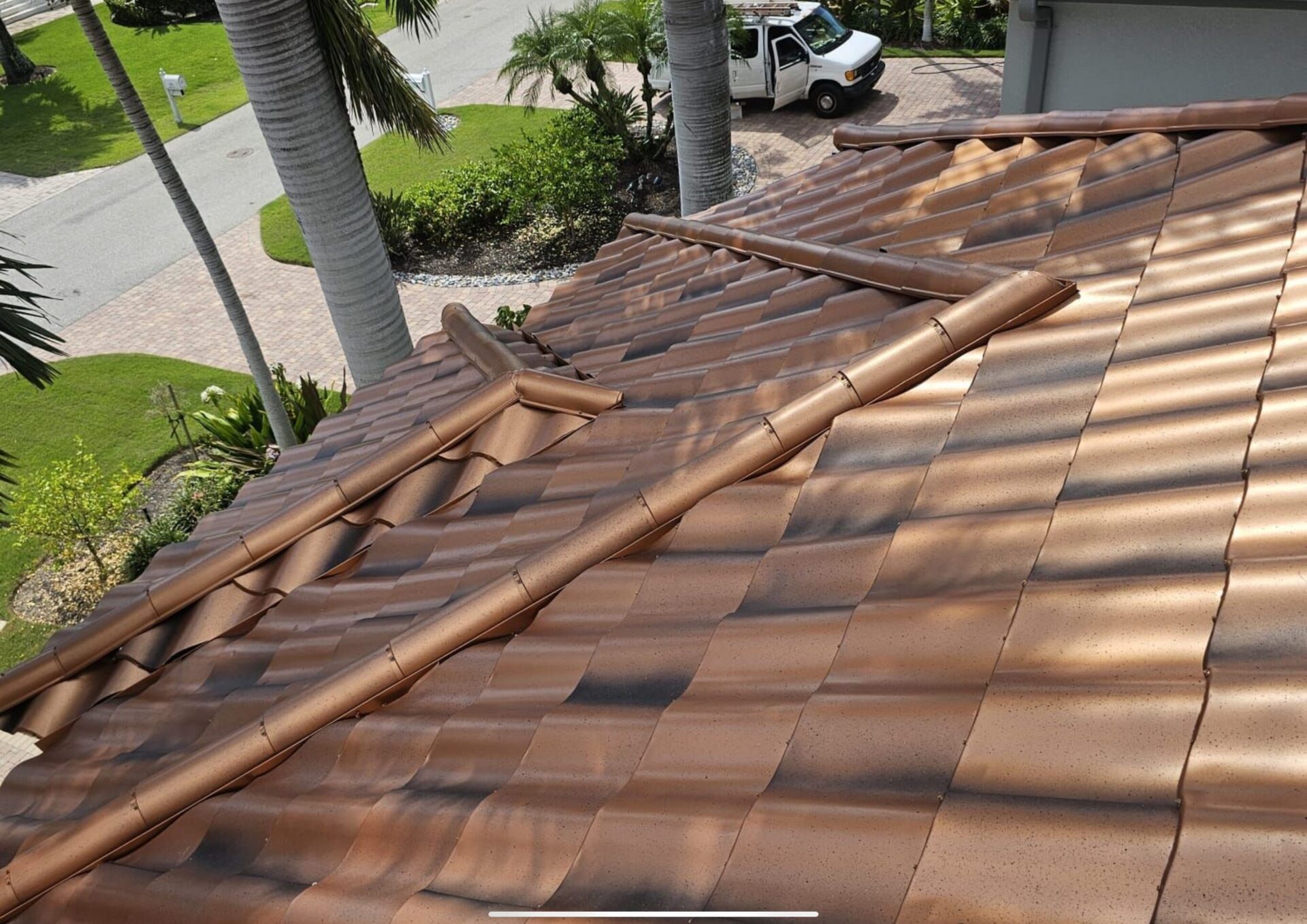 after photo of new metal spanish tile roof installed in copper penny color