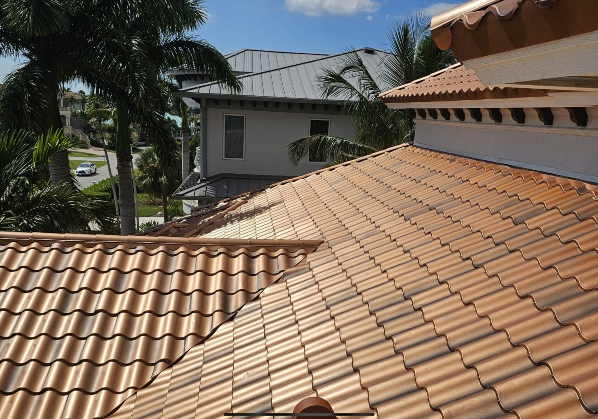 after photo of new metal spanish tile roof installed in copper penny color